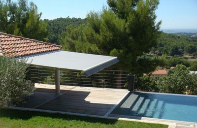 Store banne cassette aux lignes raffinées qui se distingue par son lambrequin enroulable intégré et protégé dans la barre de charge et par son éclairage à LED intégré aux bras.